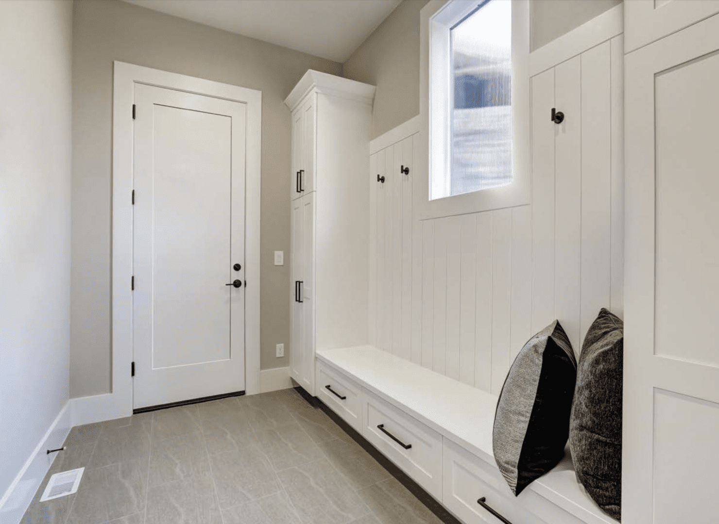 A white room with a bench and a door.